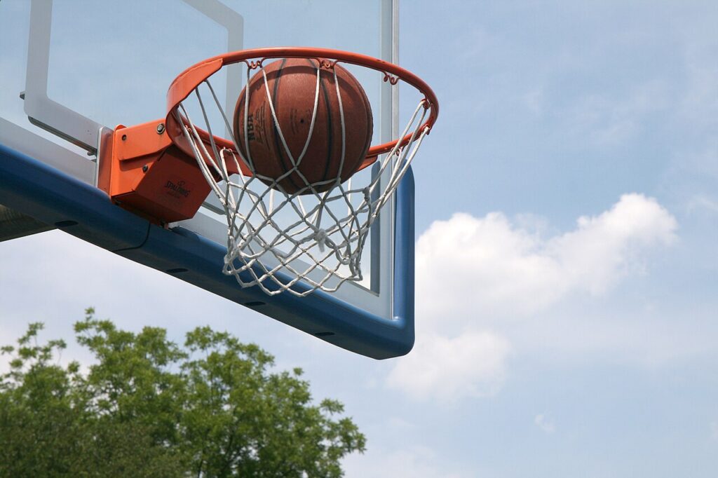 Balón de baloncesto en una canasta. Fotografía ilustrativa de archivo.